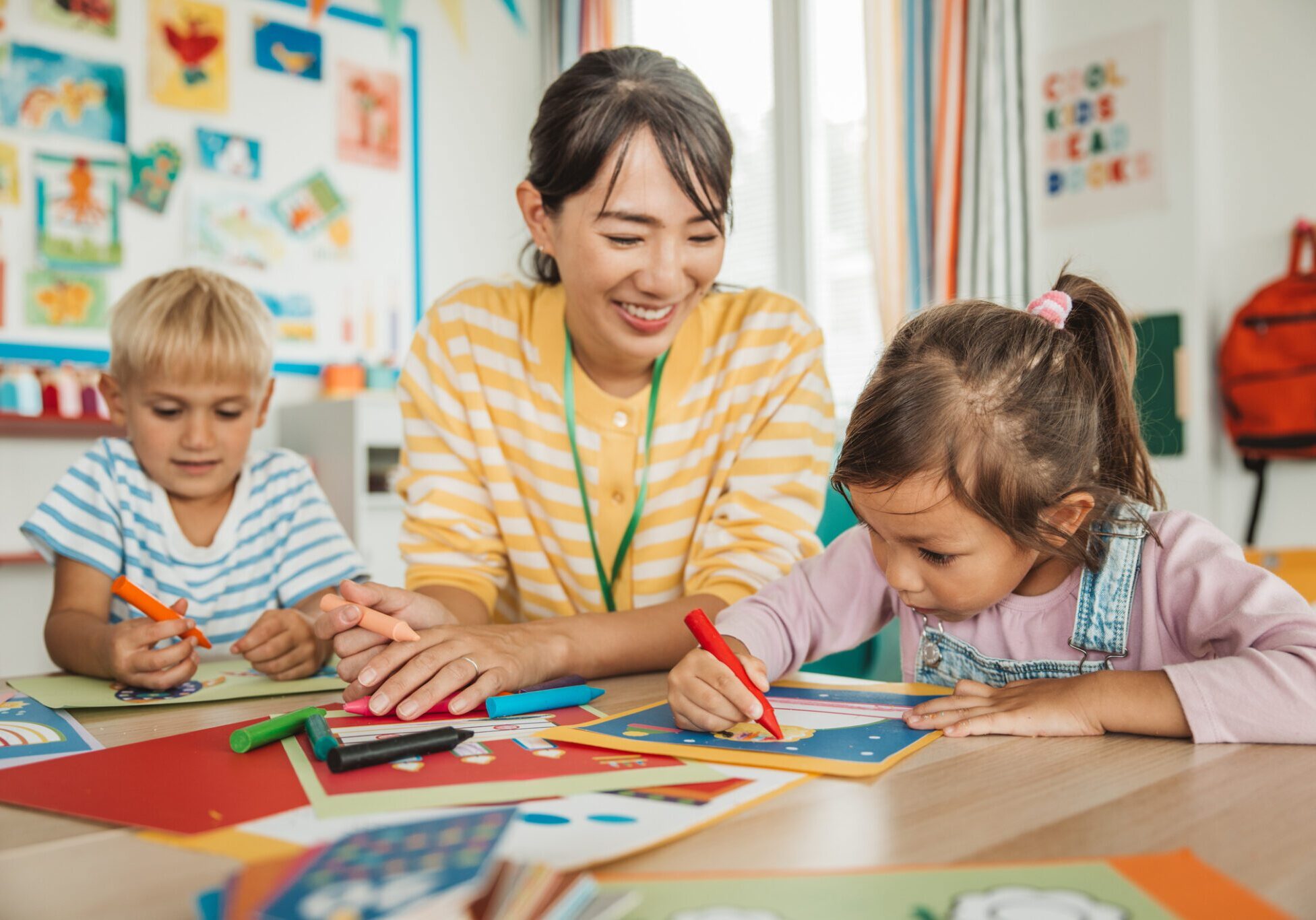 Teacher guiding children in classroom art activity